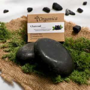 Organic hand made charcoal soap with organica box packing with some charcoal pieces.